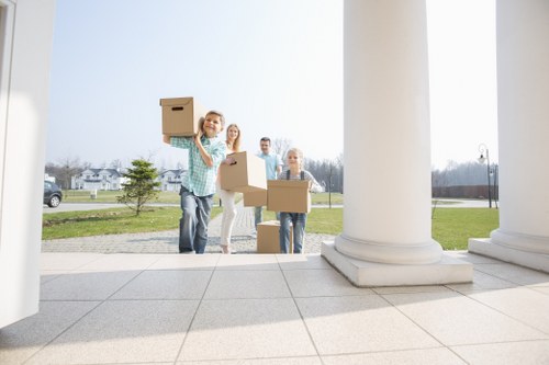 Home moving team handling boxes and furniture in a Redbridge residential street